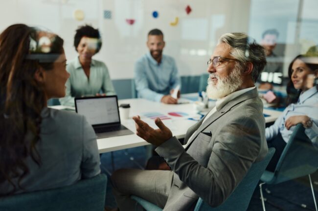 M&A-Meeting-2023 Ein erfahrener Geschäftsmann im Gespräch mit seinem Kollegen bei einer Besprechung im Büro